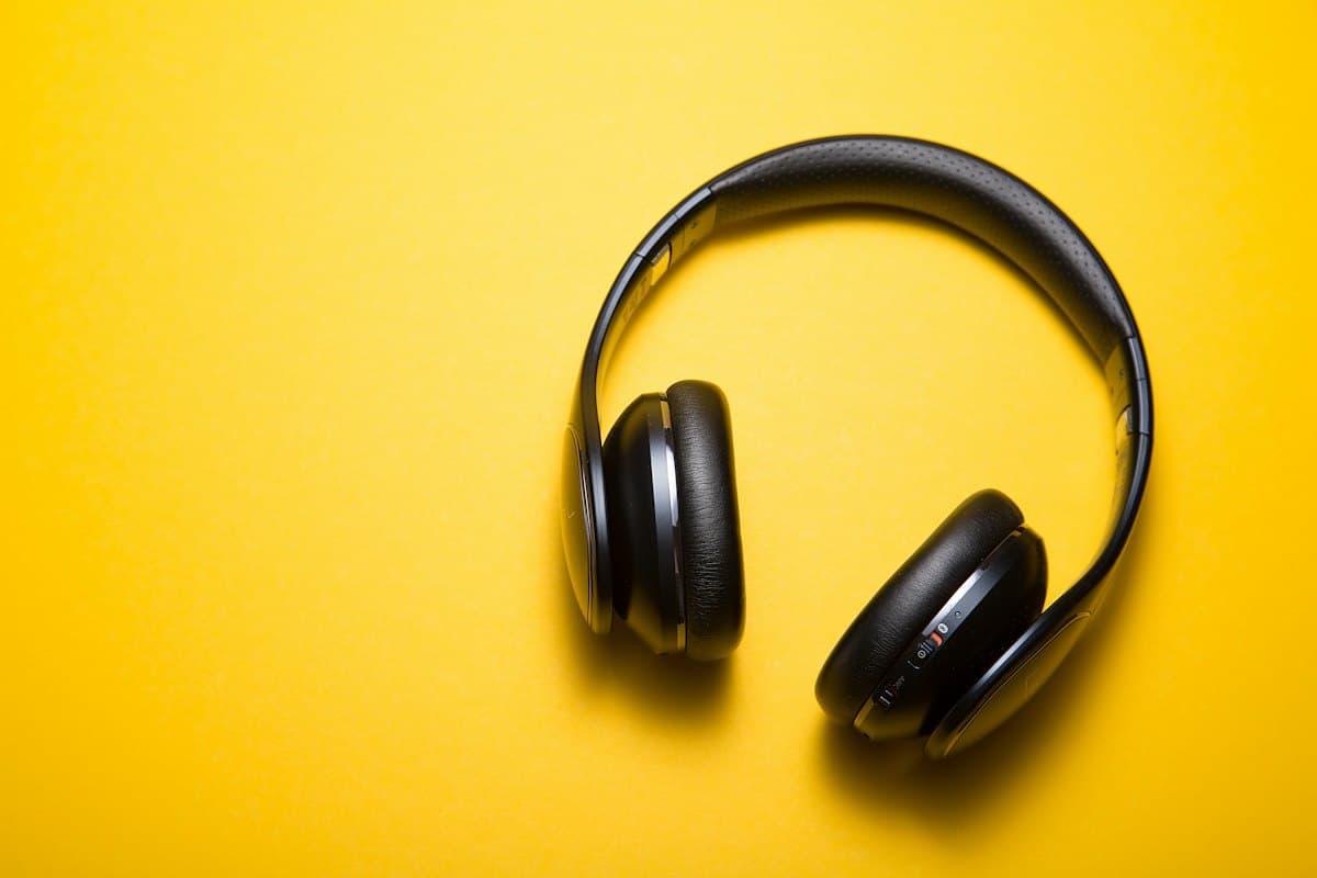 Black over-ear headphones on a saturated yellow backdrop