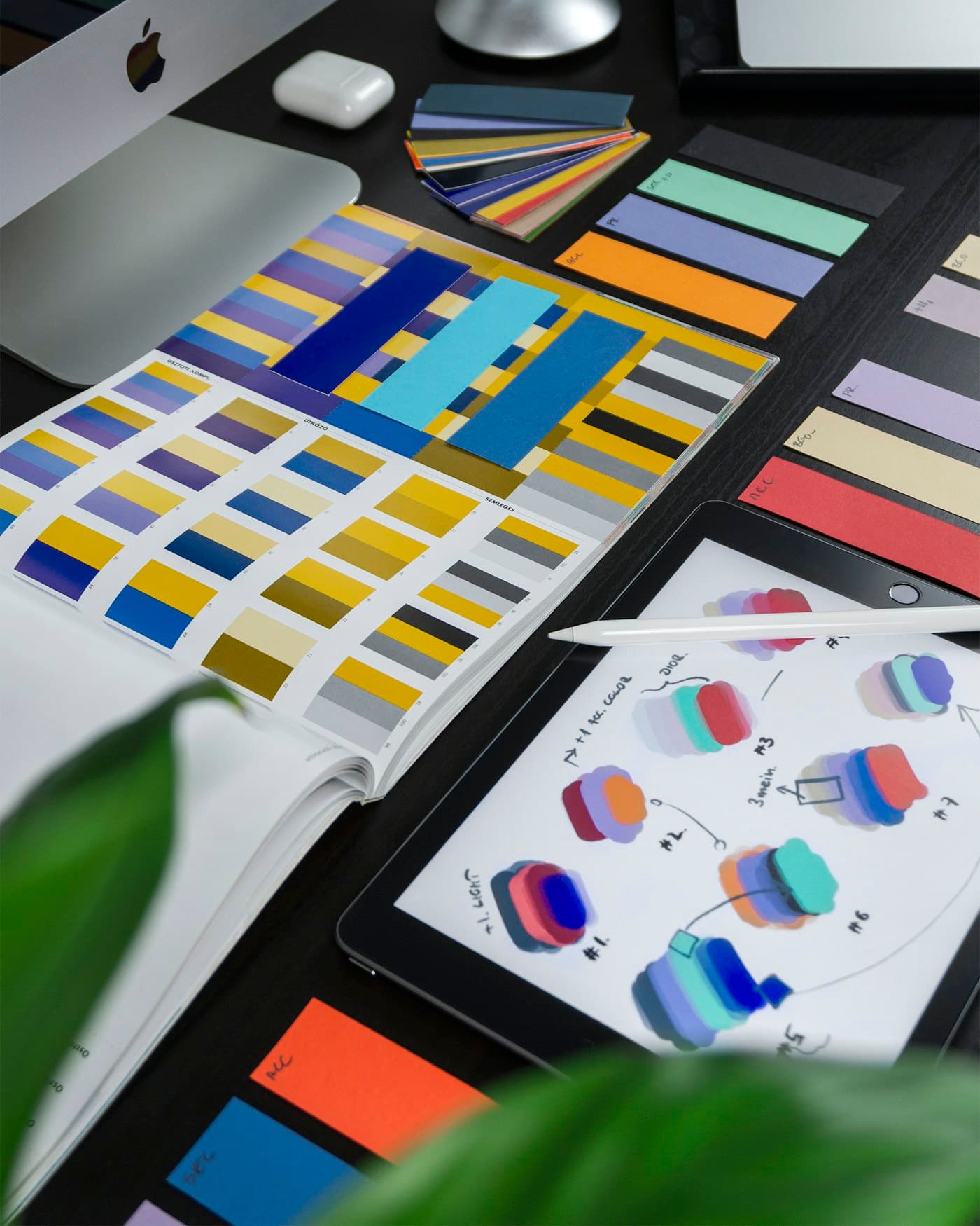 Colour swatches and printed palettes spread across a design desk